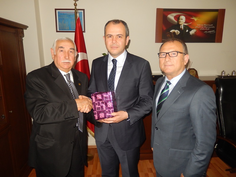 Kocaeli Kandıralılar Derneği Başkanı Erdoğan Görgün ve Günay Gülcü, Derince İlçe Emniyet Müdürü Yusuf Aydın'a Derneğin hediyesini takdim ederken